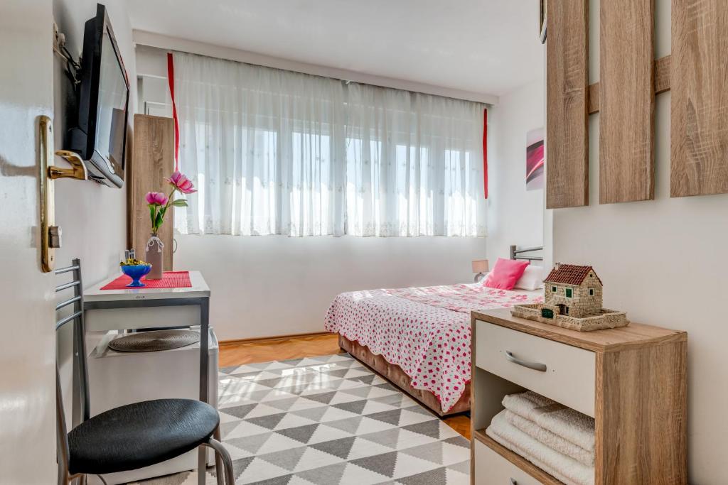 Habitación pequeña con cama y escritorio con silla. en Rooms Alijev, en Split
