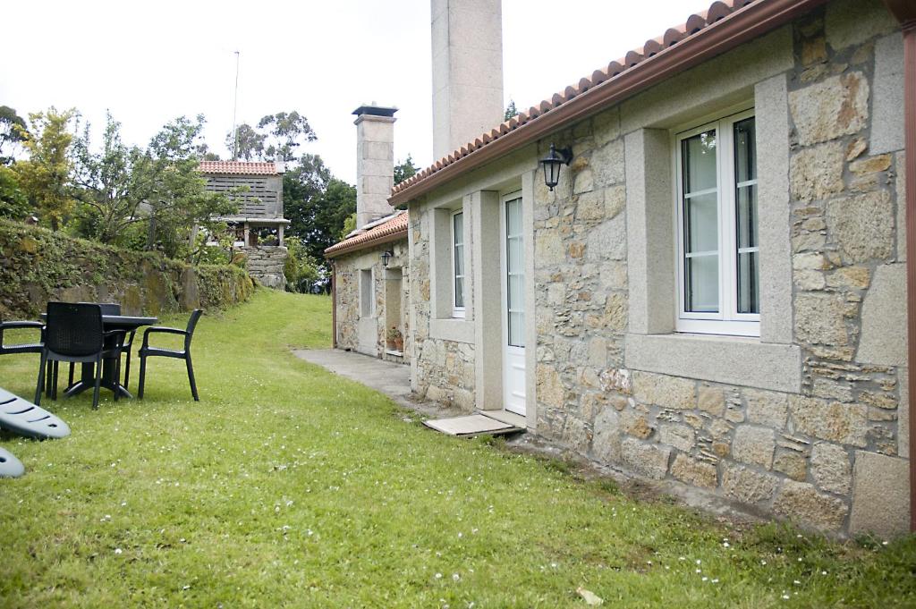 Casa con patio con mesa y ventana en Casa Playa de Balares, en Ponteceso