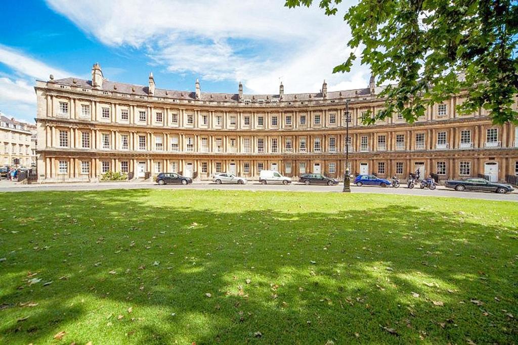 a large building with a grass field in front of it at The Circus Apartment in Bath