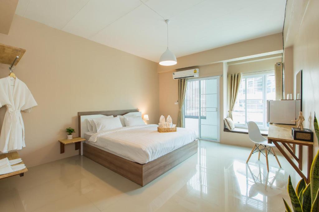 a bedroom with a bed and a large window at Habitat Hotel in Chiang Mai