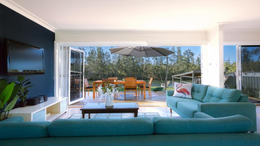 a living room with a blue couch and a table at The River Retreat in Sussex inlet