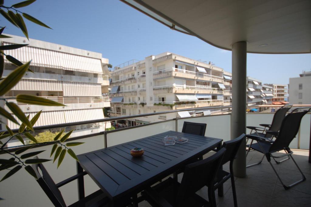 una mesa azul y sillas en un balcón con edificios en Lets Holidays Voramar Apartment, en Tossa de Mar