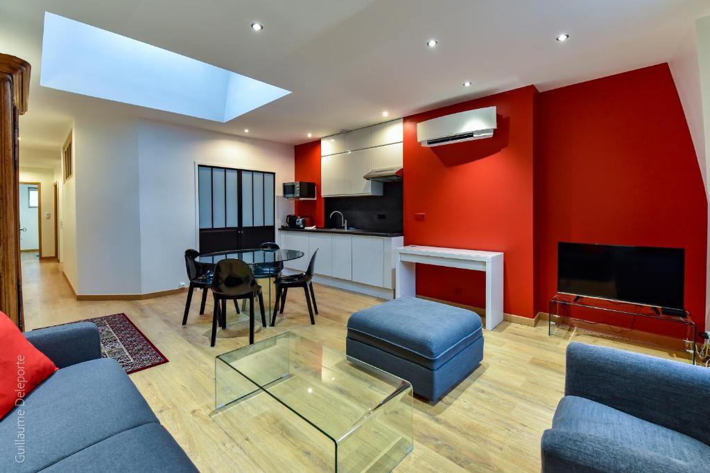 a living room with a couch and a table and a kitchen at Cité GuiDe in Arras