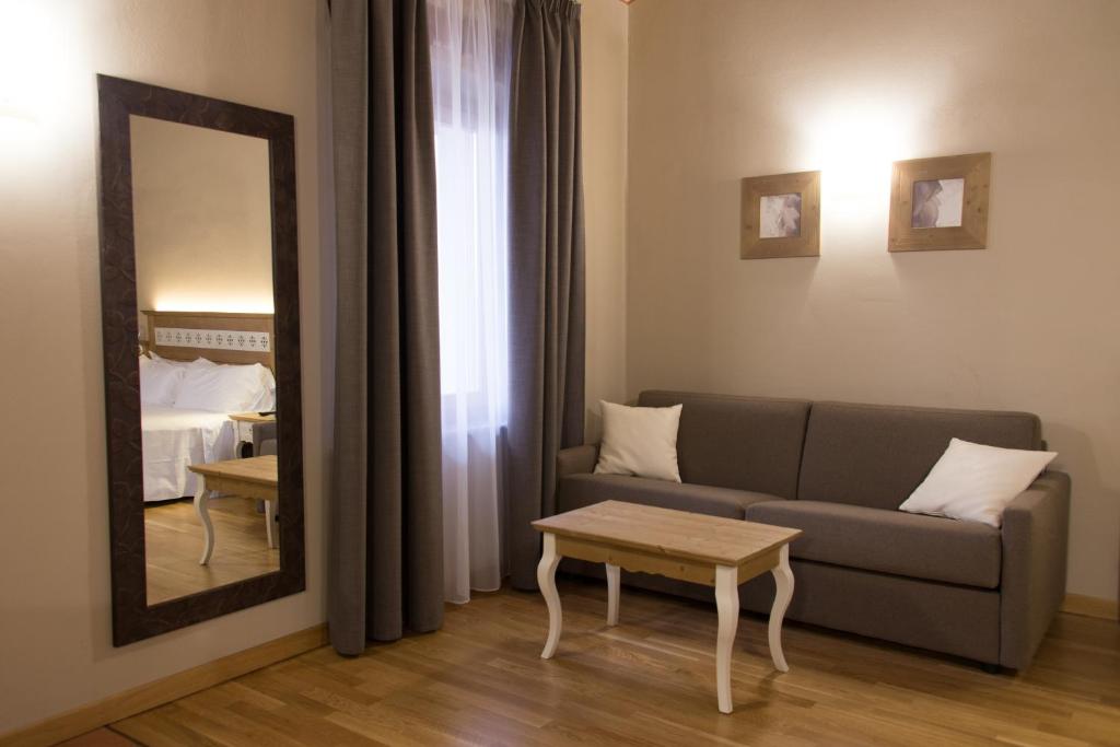 Hotel Sesmones في لودي: غرفة معيشة مع أريكة ومرآة