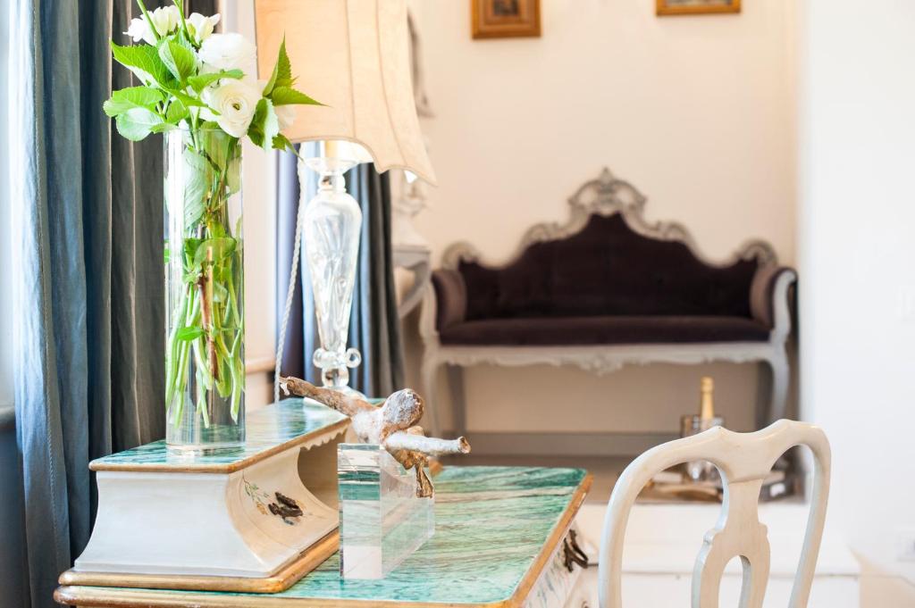 uma mesa de vidro com um vaso de flores e uma cadeira em Country Lodge B&B em Siena