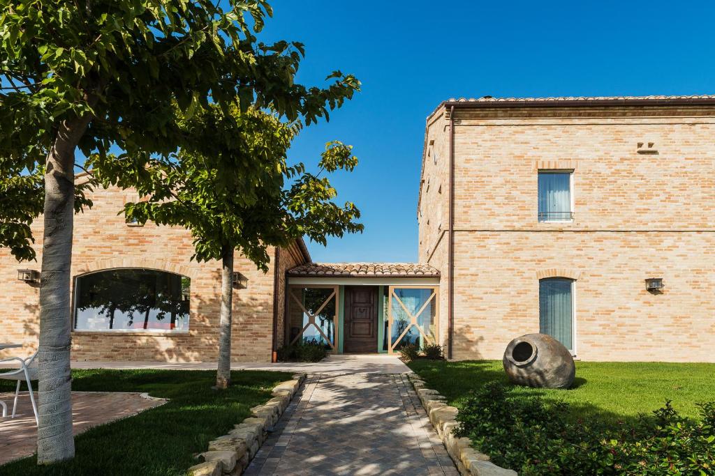 a brick building with a door and a tree at Officina del Sole in Montegiorgio