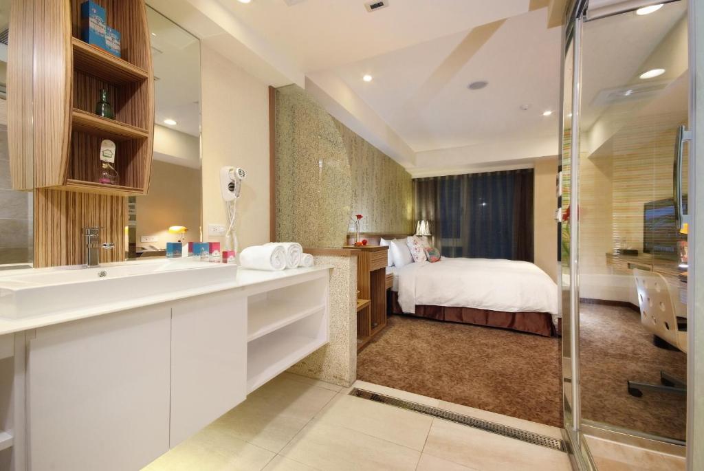 a bathroom with a sink and a bed in a room at Homey House in Taipei