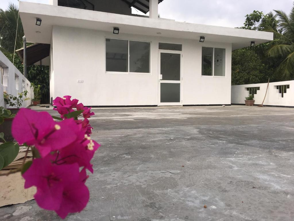 ein Haus mit rosa Blumen davor in der Unterkunft Ceylon Ramble Villa in Hikkaduwa
