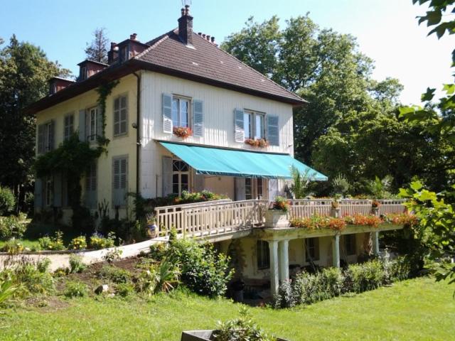 Casa blanca grande con porche y balcón en Chambres d'hôtes Le Petit Roche, en Arc-et-Senans