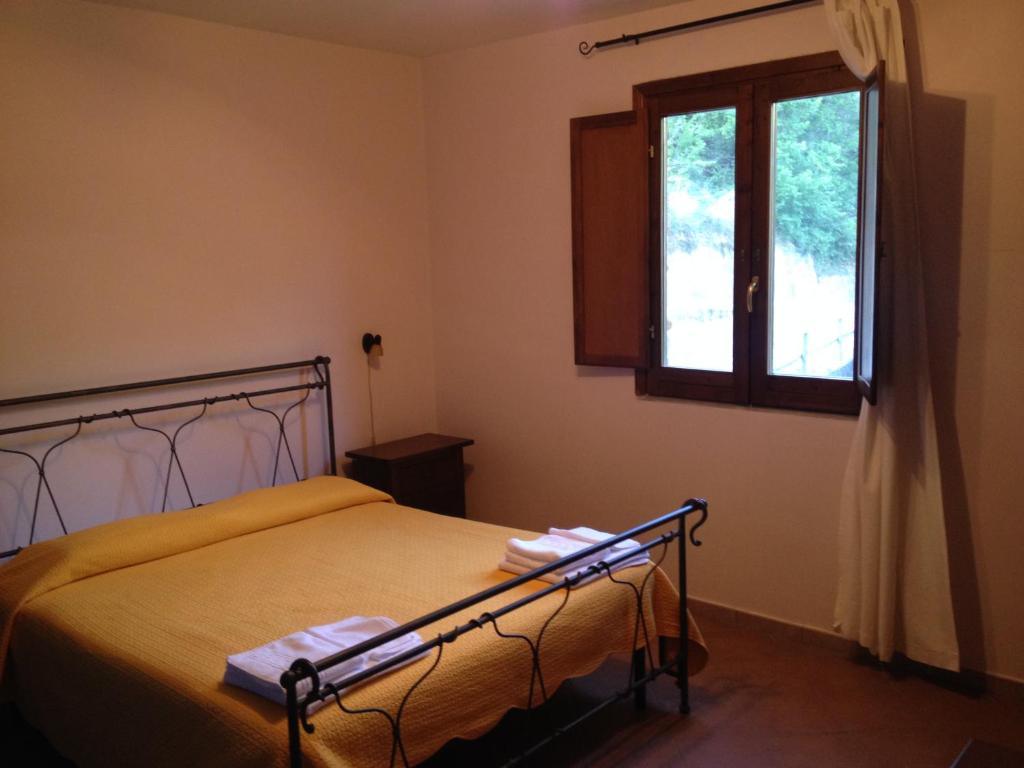 a bedroom with a bed and a window at Locanda La Corte in Serramezzana