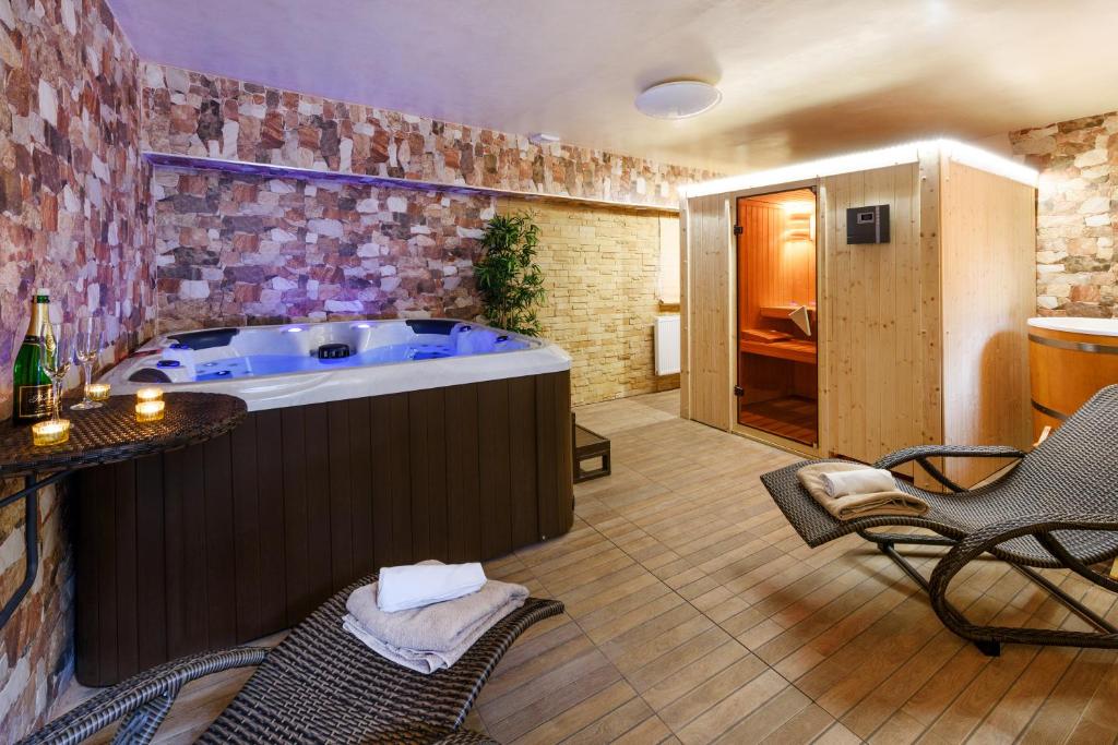 uma banheira de hidromassagem num quarto com mesa e cadeiras em Wellness Apartmány Andrea em Zdíkov
