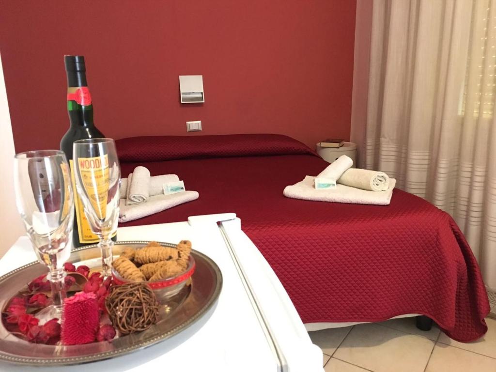 a table with a bottle of wine and a plate of food at Bed and Breakfast Almaran in Trapani