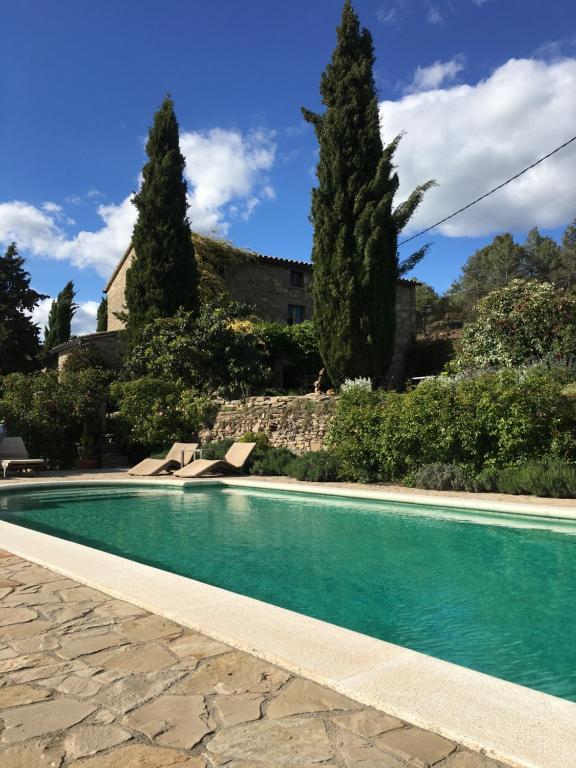 una piscina frente a una casa con árboles en Celler Colltor, en Santa María de Oló