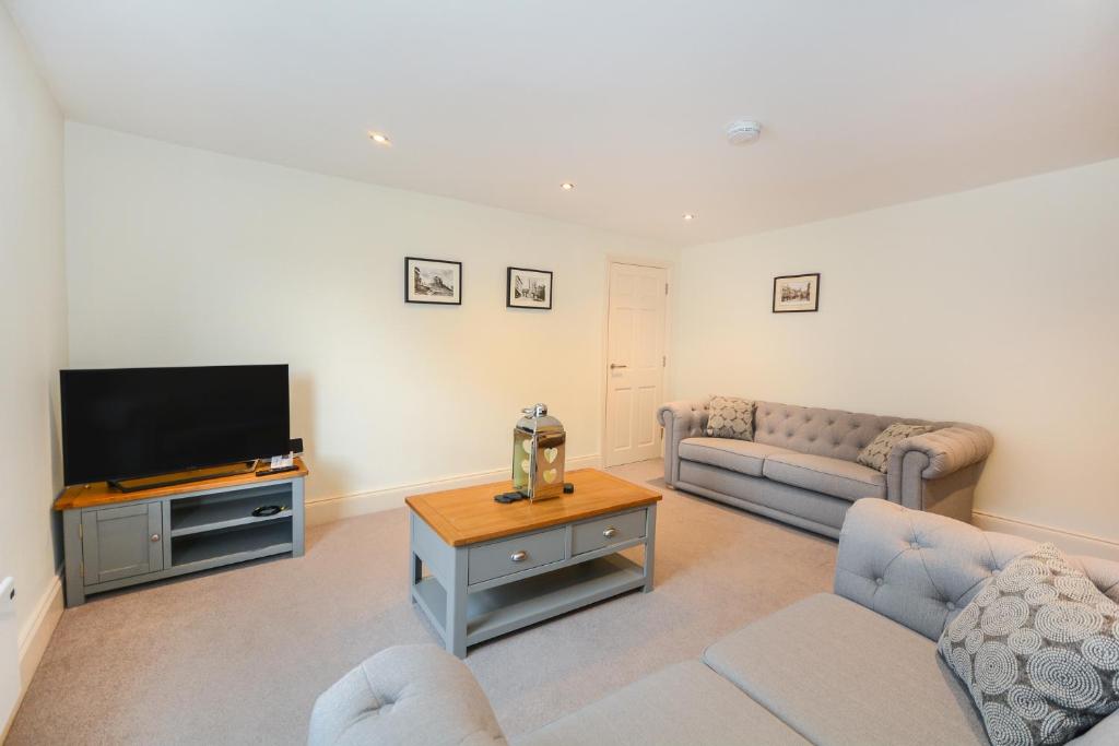 a living room with a couch and a tv at Minster's Keep- Stylish Apartment Near York Minster in York