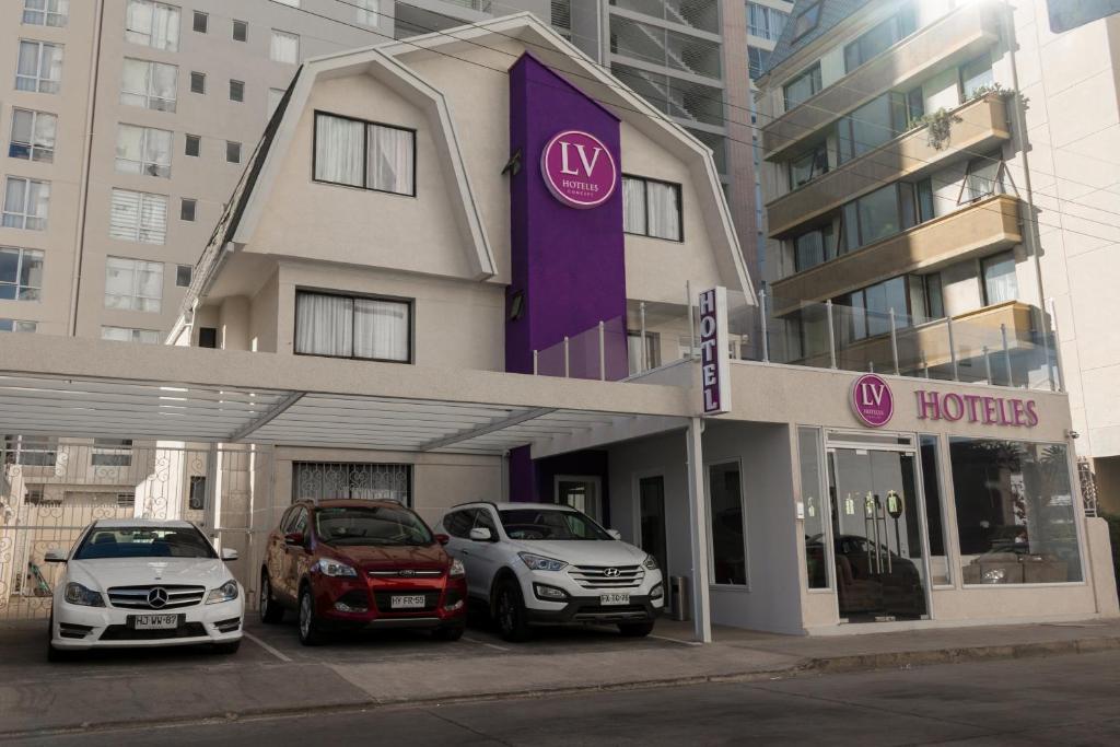 two cars parked in front of a hotel at LV Hoteles Boutique in Viña del Mar