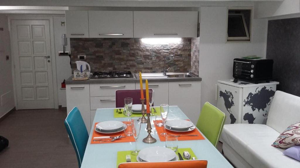een keuken met een tafel en stoelen en een keuken met een tafel en een tafel bij Taormina Rainbow House in Taormina