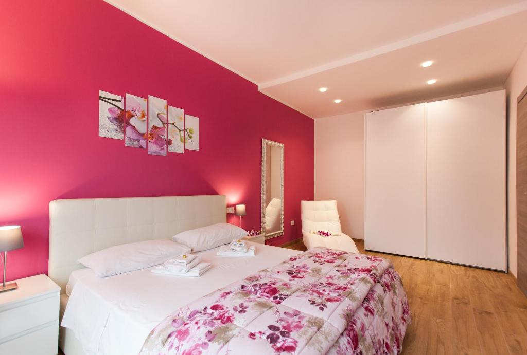 a bedroom with a white bed and a pink wall at Bongiorno Home Private Free Parking Venice 10' in Marghera