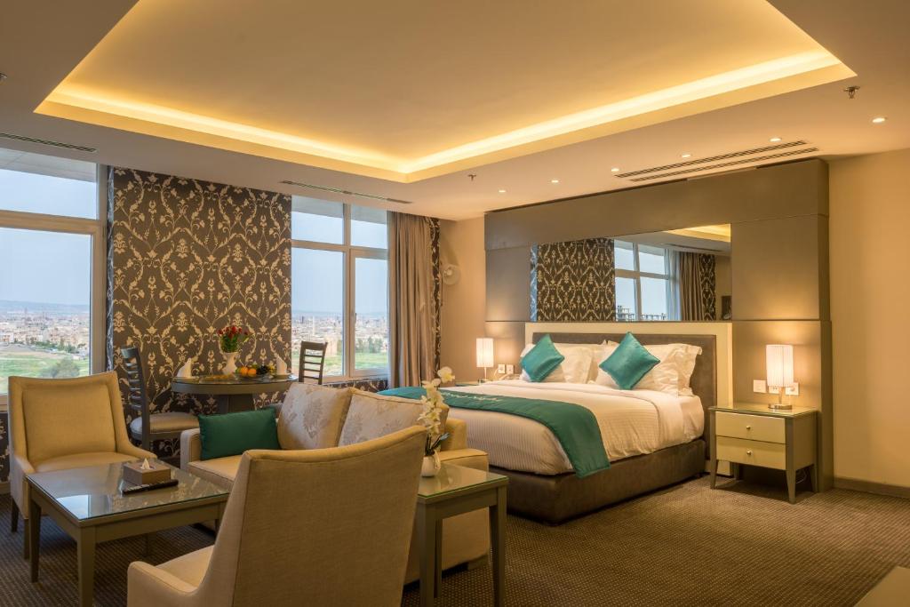 a hotel room with a bed and a large window at La Roche Hotel in Erbil