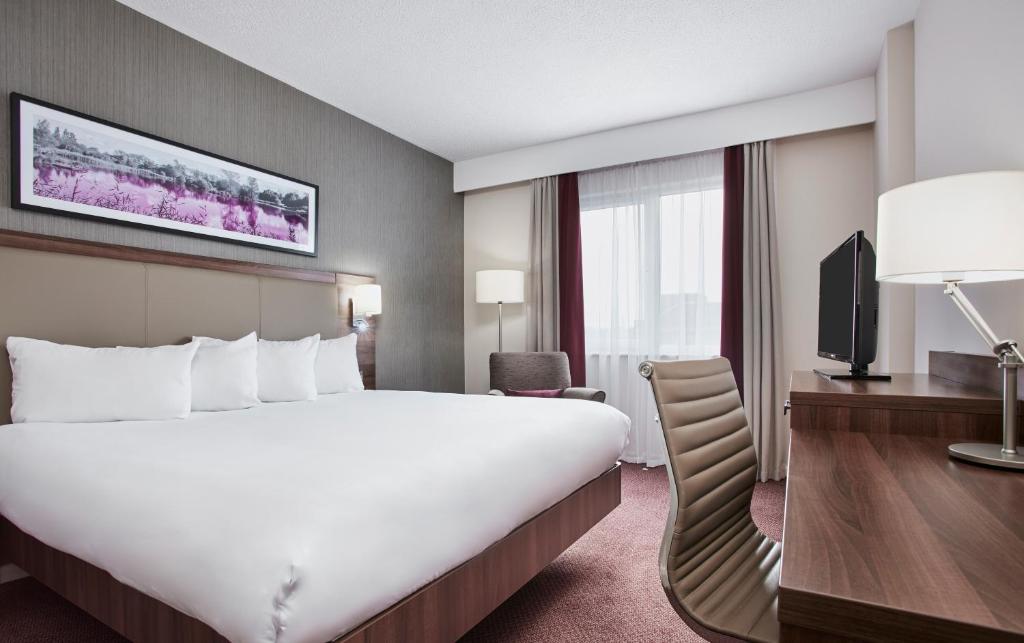 um quarto de hotel com uma cama grande e uma televisão em Leonardo Hotel Derby em Derby