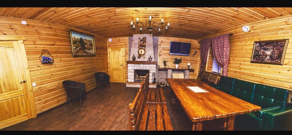 a wooden room with a wooden table and a fireplace at Hotel Bannyi Dvor in Uzyn