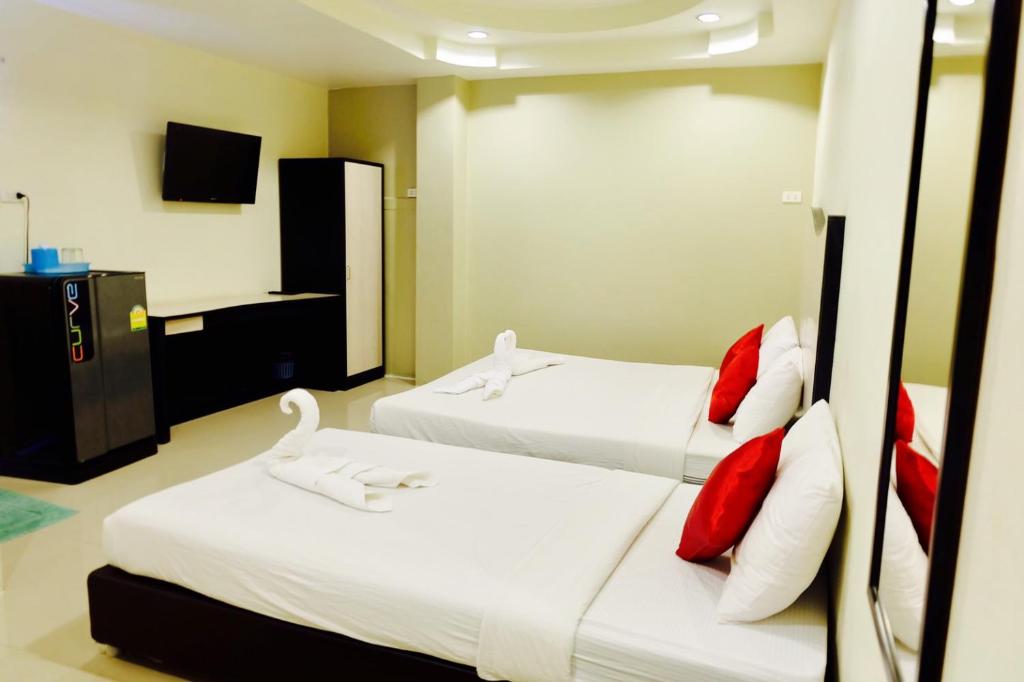 um quarto com 2 camas com almofadas vermelhas e brancas em Better Place Hotel em Ubon Ratchathani