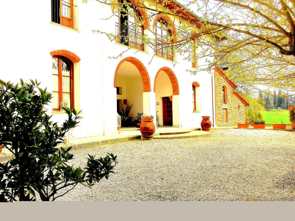 a large white building with a courtyard in front of it at Bacco a Petroio in Vinci