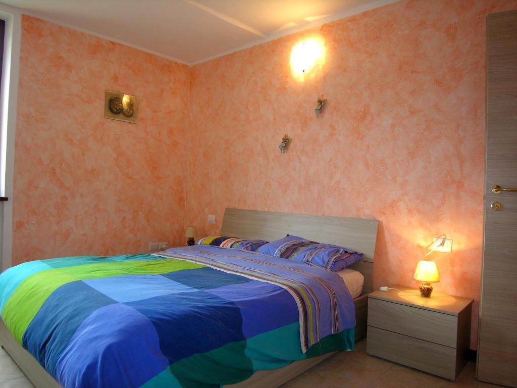 een slaapkamer met een bed met een kleurrijk dekbed bij Casa Gabriella in San Siro