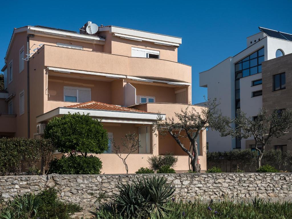 a house in front of a building at Apartments Nino 1 in Zadar