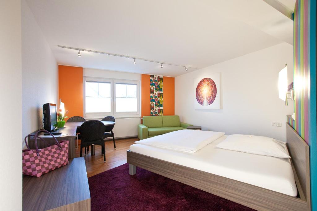 トゥットリンゲンにあるB&B Appartements Bischof & Bürk GbRのベッド、デスク、椅子が備わるホテルルームです。