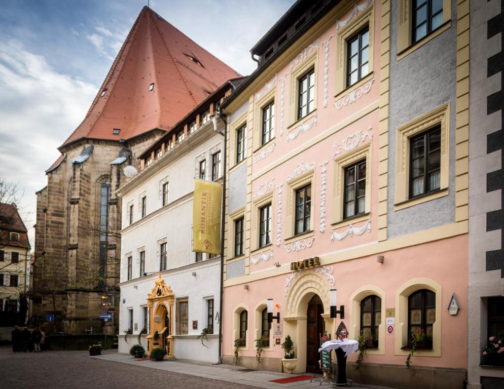 a building with a clock tower on a street at Romantik Hotel Deutsches Haus in Pirna