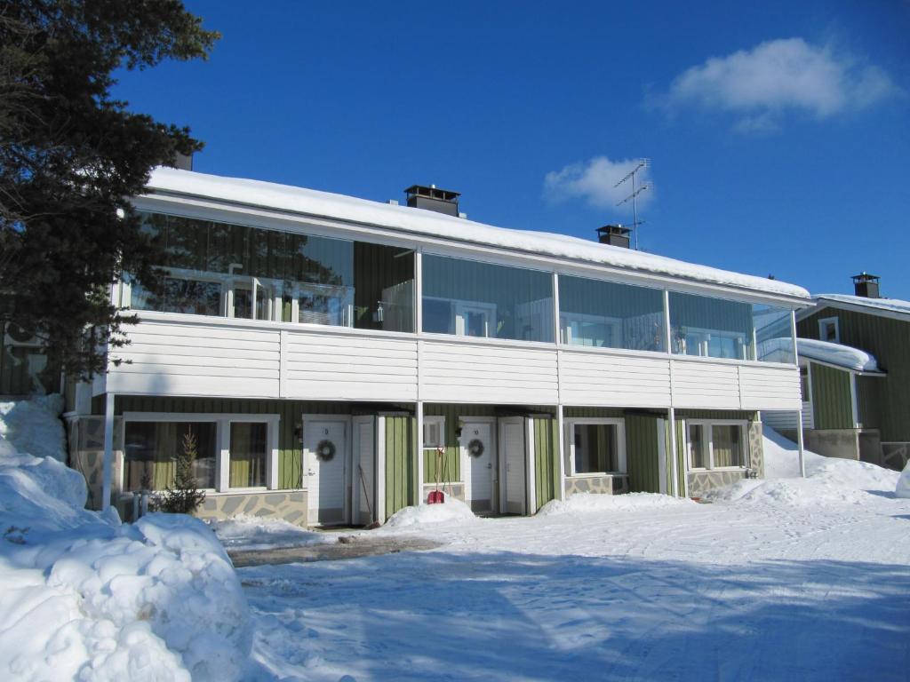 a large building with snow in front of it at Lapin Kutsu Apartments in Saariselka