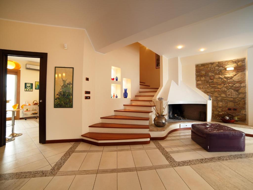 a living room with a staircase and a fireplace at Villa Anna in Santa Teresa di Riva