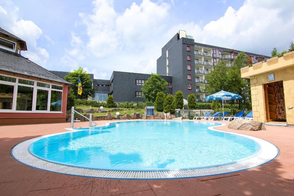 a large swimming pool in the middle of a building at Aparthotel am Rennsteig in Wurzbach