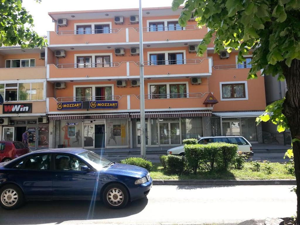 a blue car parked in front of a building at Hotel Viv in Trebinje