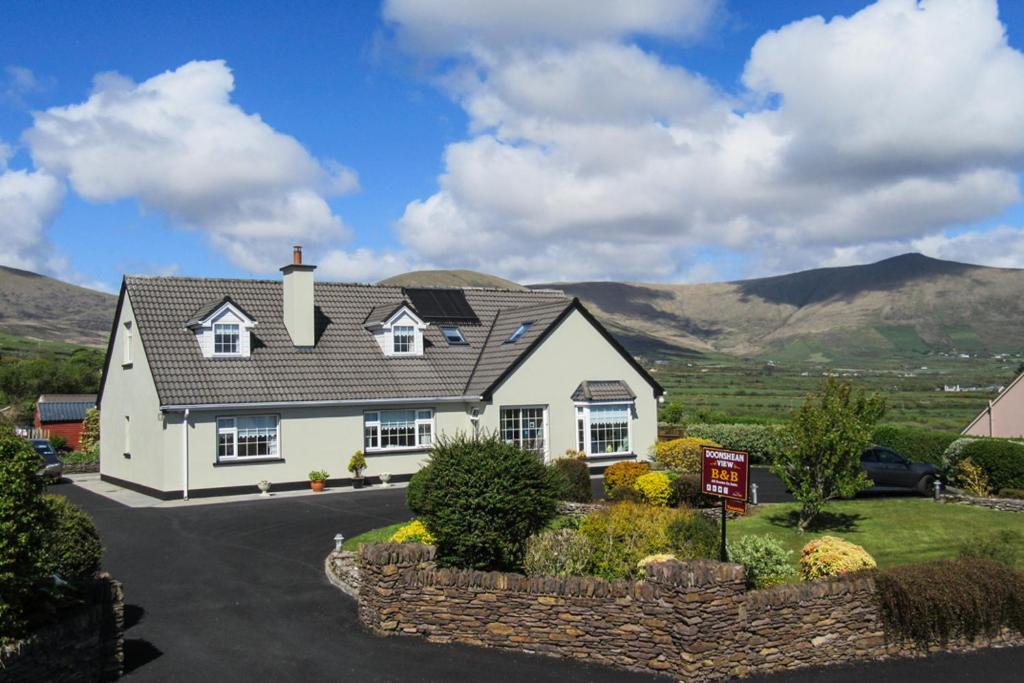 a white house with mountains in the background at Doonshean View Bed and Breakfast in Dingle