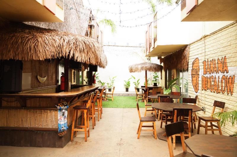 a patio area with tables, chairs and umbrellas at Banana Bungalow West Hollywood Hotel & Hostel in Los Angeles
