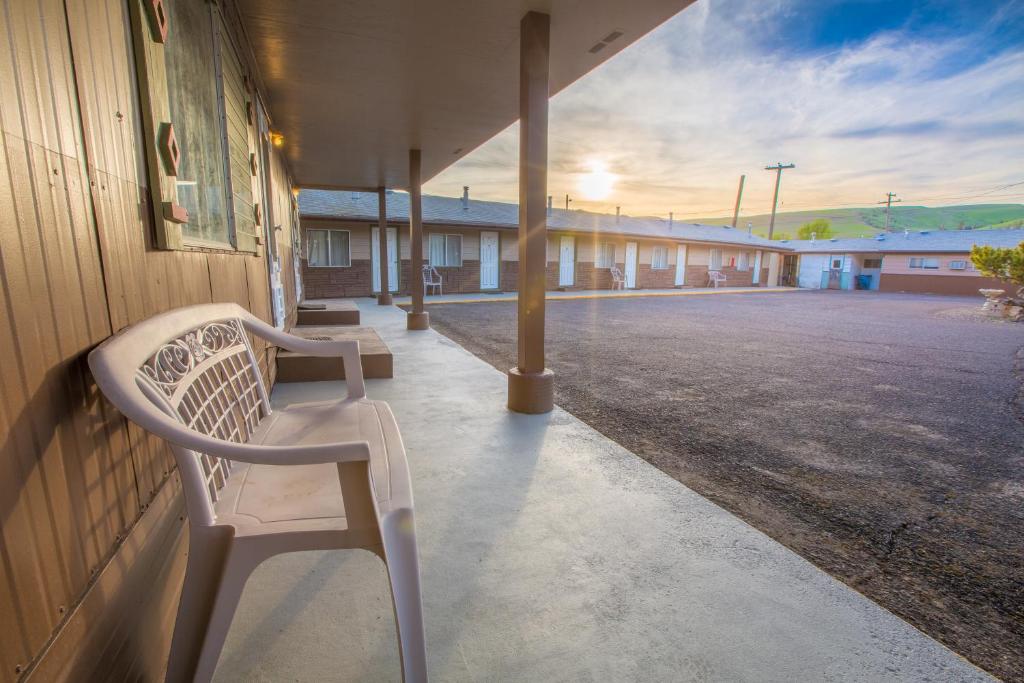 a white bench sitting on the side of a building at Dayton Motel in Dayton