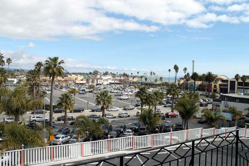 Blick auf einen Parkplatz mit Autos und Palmen in der Unterkunft Fireside Inn By The Beach Boardwalk & Bowling in Santa Cruz