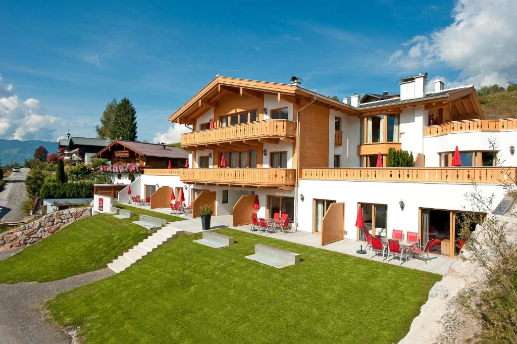 a large building with a yard with green grass at AlpenParks Appartements Maria Alm in Maria Alm am Steinernen Meer