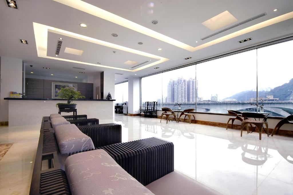 a living room with couches and a table and chairs at Beautiful Hotel Taipei in Xindian
