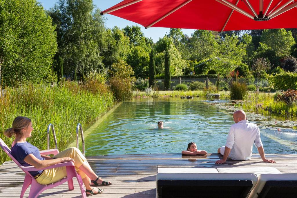 a group of people sitting under an umbrella in a pond at Planetrees Estate in Beechworth