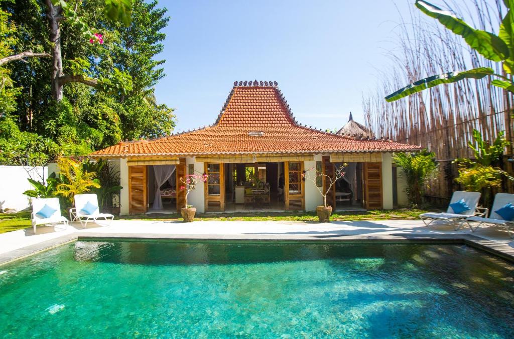 uma casa com piscina em frente a uma casa em Lata Lama em Lovina