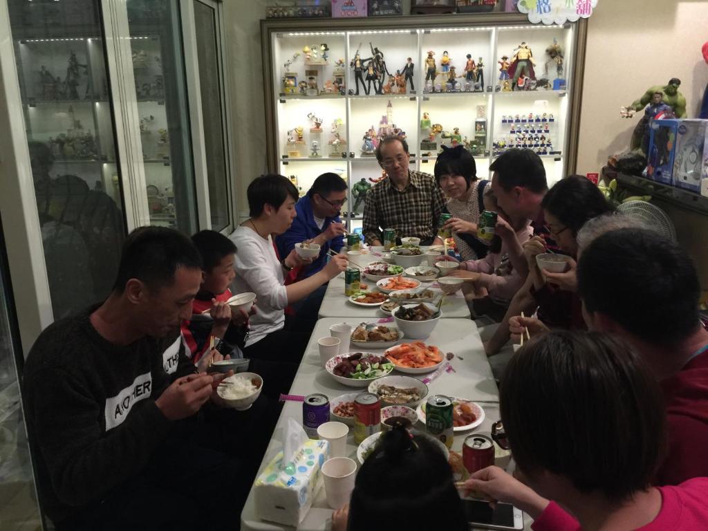 a group of people sitting around a table eating food at Doll House Lodge in Hengchun South Gate