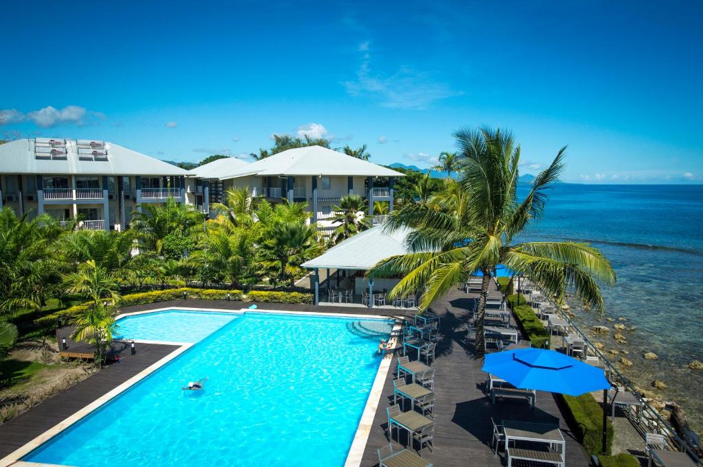 an aerial view of a resort with a swimming pool and the ocean at Heritage Park Hotel in Honiara