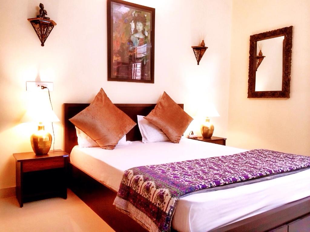 um quarto com uma grande cama branca e 2 candeeiros em The Buddhayan Villa em Jaipur
