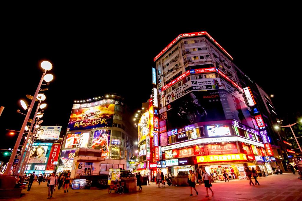 un grupo de edificios altos en una ciudad por la noche en Hotel 6 - Ximen, en Taipéi