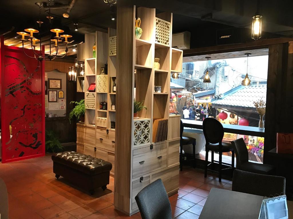 a room with a table and some chairs and a window at Chiu Chunt Dint B&amp;B in Jiufen