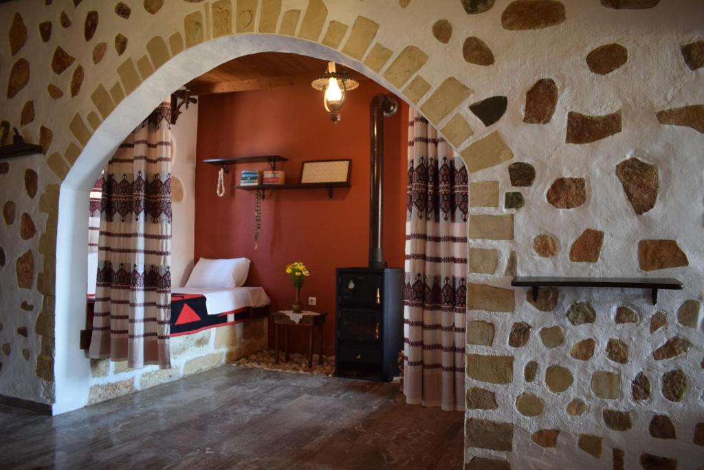 Megála KhoráfiaにあるEirini's Stone Houseのアーチ型のベッドルーム(ベッド付)