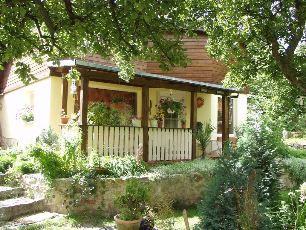 a house with a porch with flowers on it at Ferienhaus Hagenwinkel in Gernrode - Harz