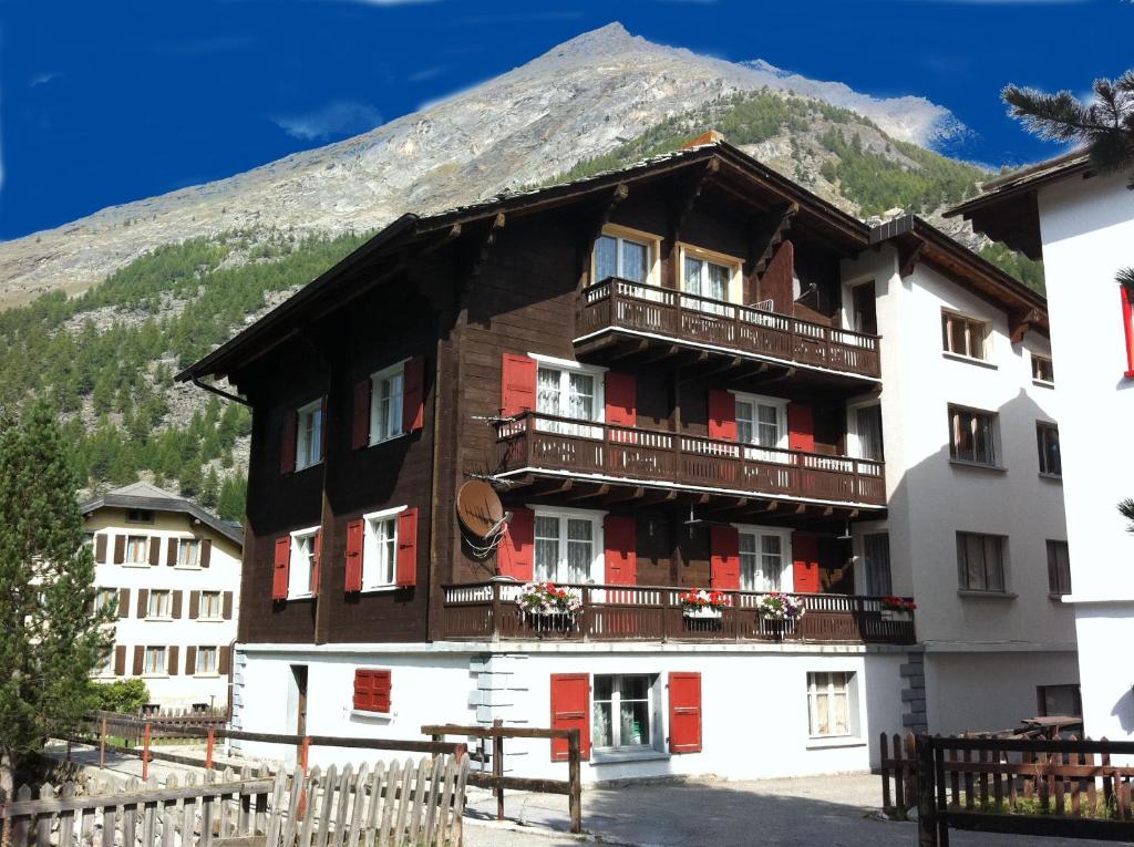 a building with a mountain in the background at Apartment Enzian in Saas-Almagell